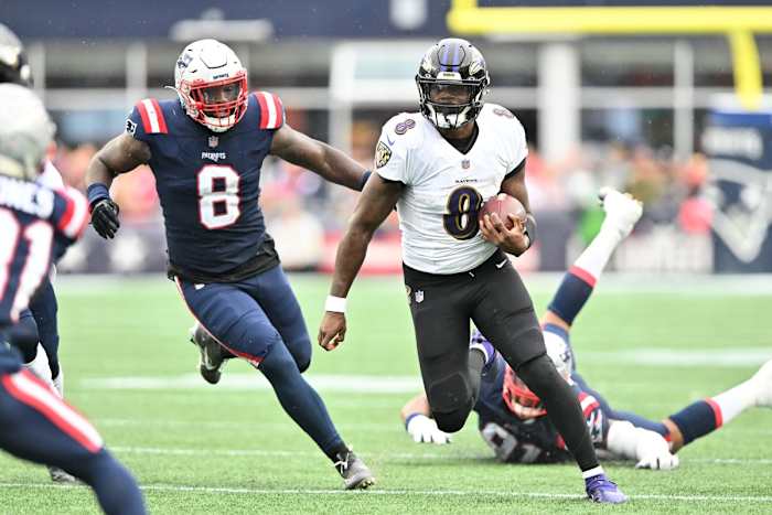 Baltimore Ravens quarterback Lamar Jackson (8) runs past New England Patriots linebacker Ja'Whaun Bentley (8). Mandatory Credit: Brian Fluharty-USA TODAY Sports